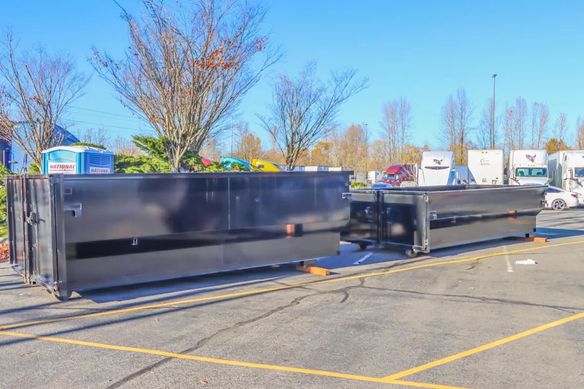 Professional dumpster rental service with roll-off container on residential driveway in Vista